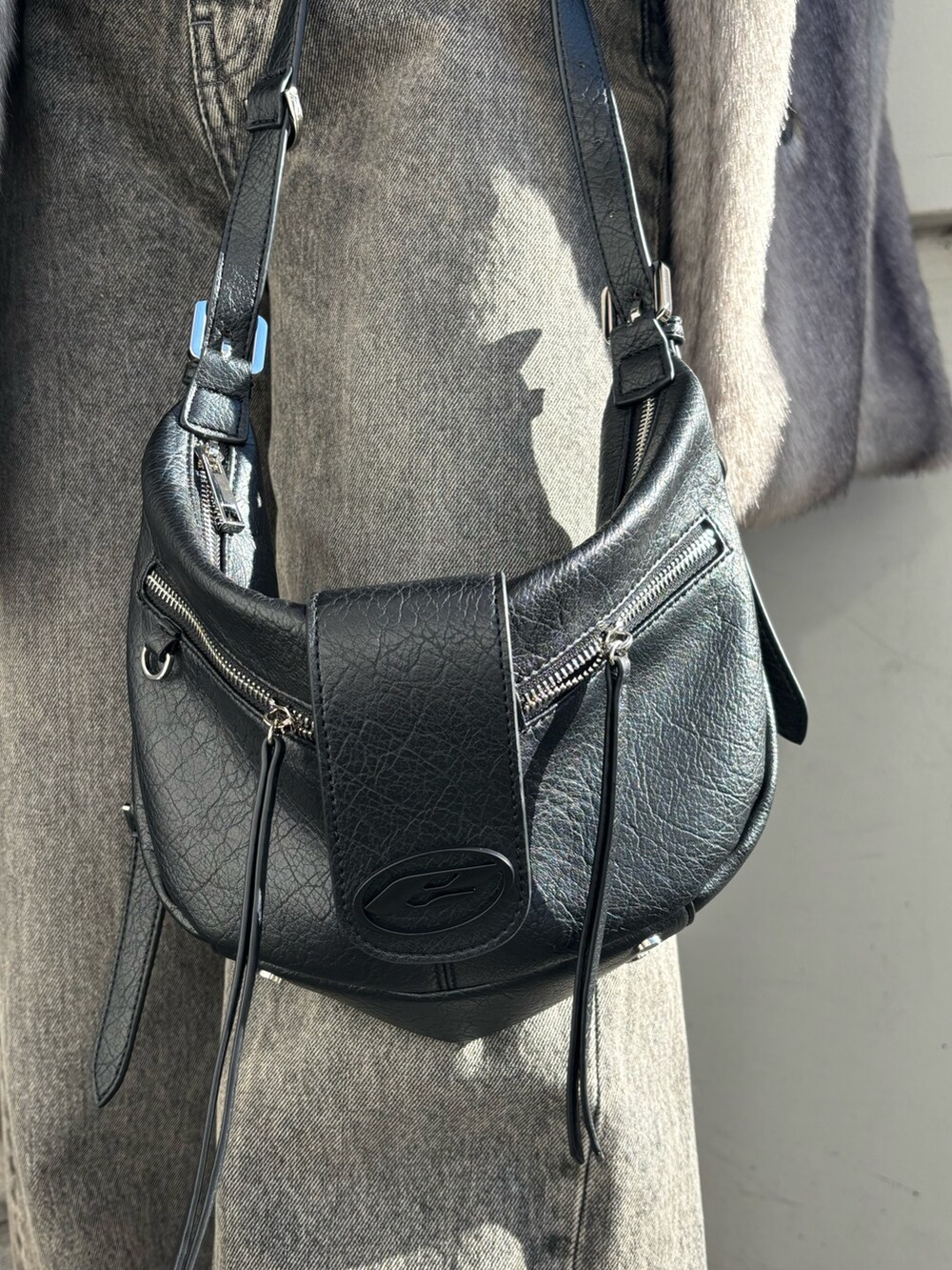 グレー系のその他アウター、ブラック系のニット/セーター、ブラック系のハンドバッグを着用したレディースの冬コーディネートの6枚目の写真