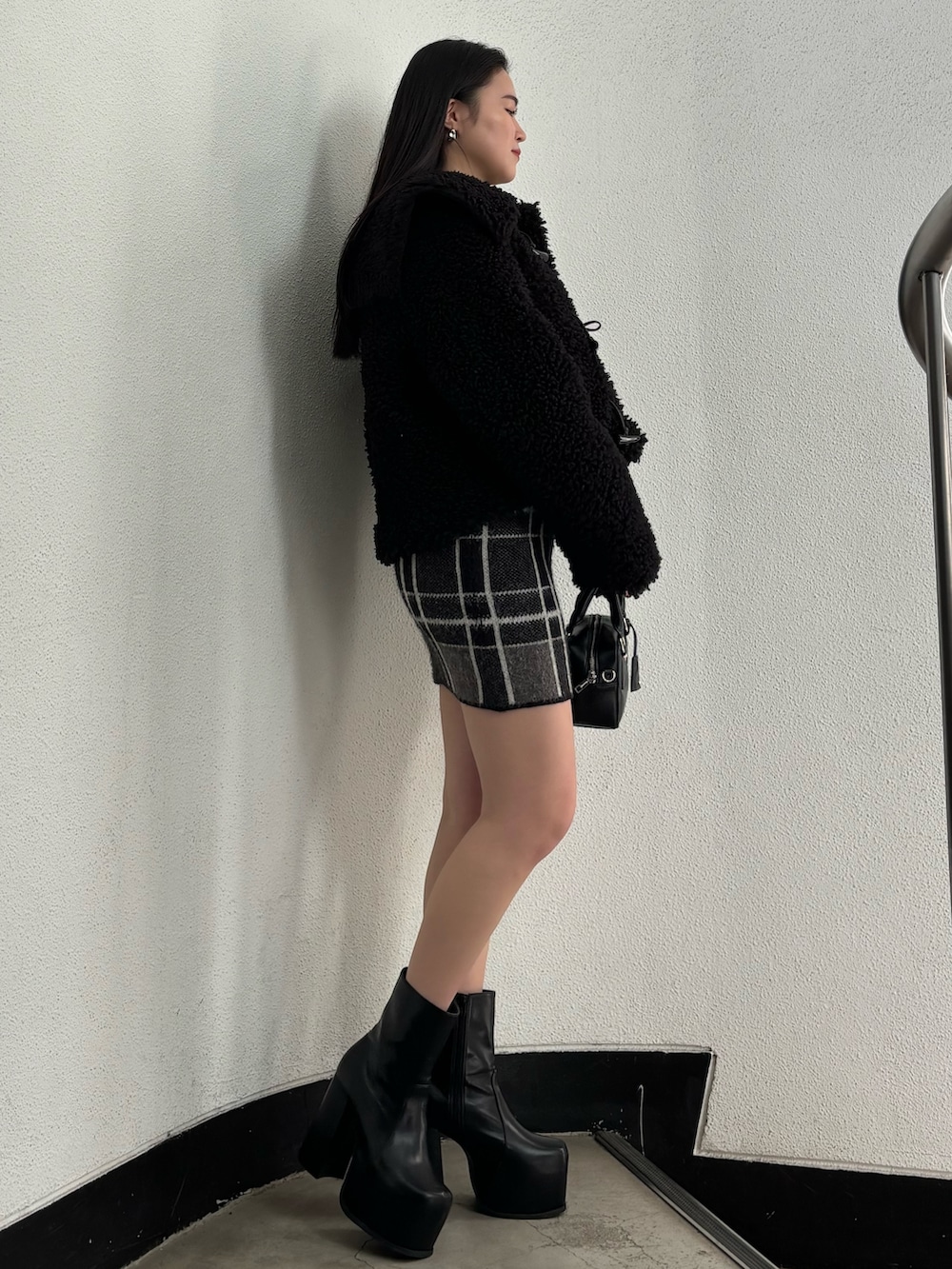 ブラック系のブルゾン、ブラック系のニット/セーター、ブラック系のスカートを着用したレディースの冬コーディネートの2枚目の写真