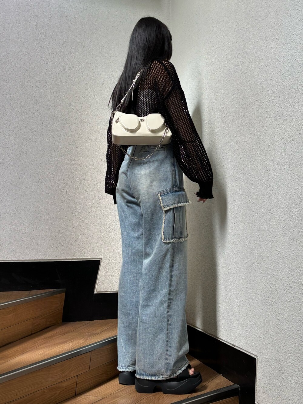 ブラック系のニット/セーター、ブルー系のデニムパンツを着用したレディースの春コーディネートの2枚目の写真