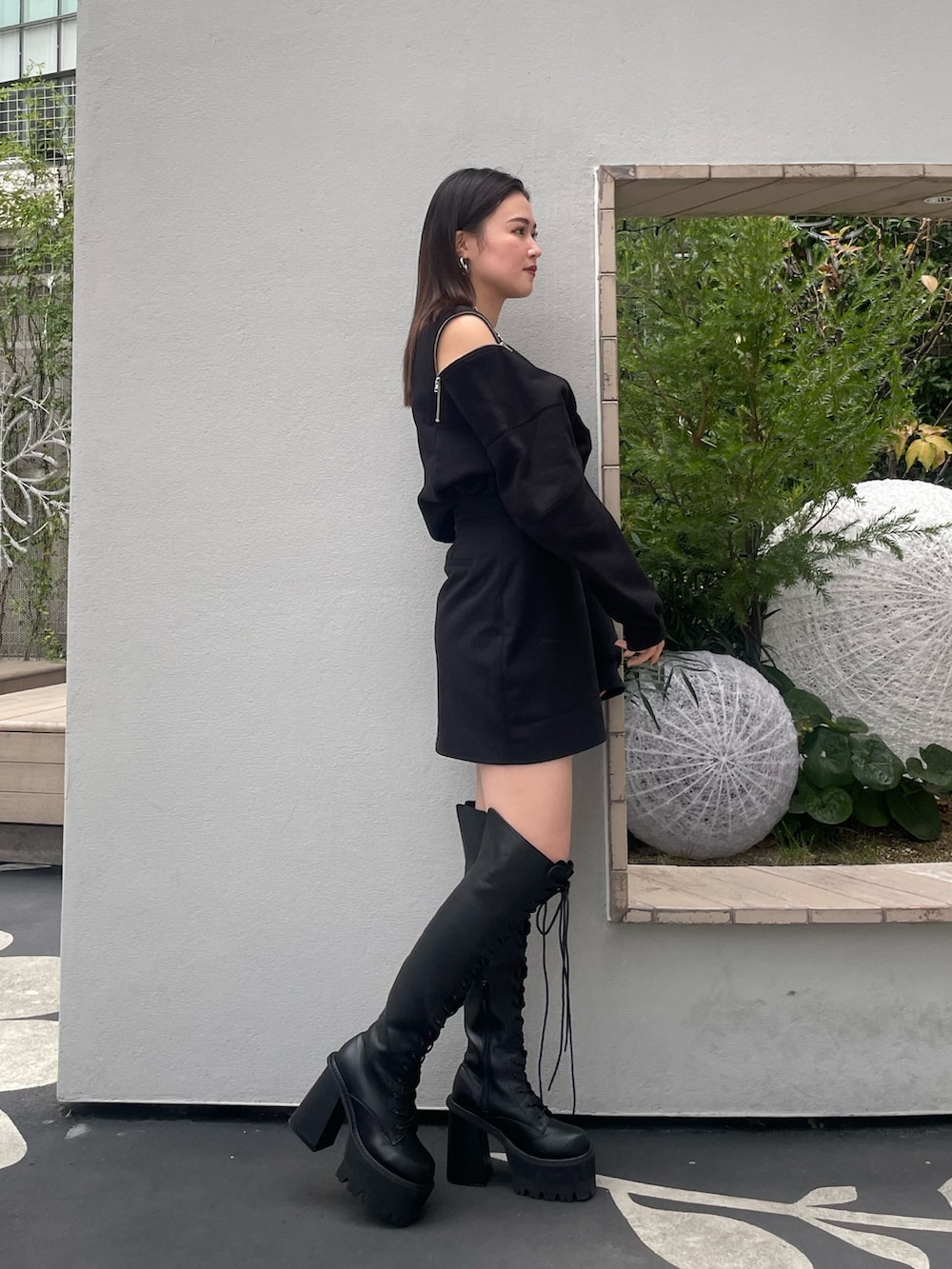 ブラック系のTシャツ/カットソー、ブラック系のスカート、ブラック系のブーツを着用したレディースの冬コーディネートの2枚目の写真