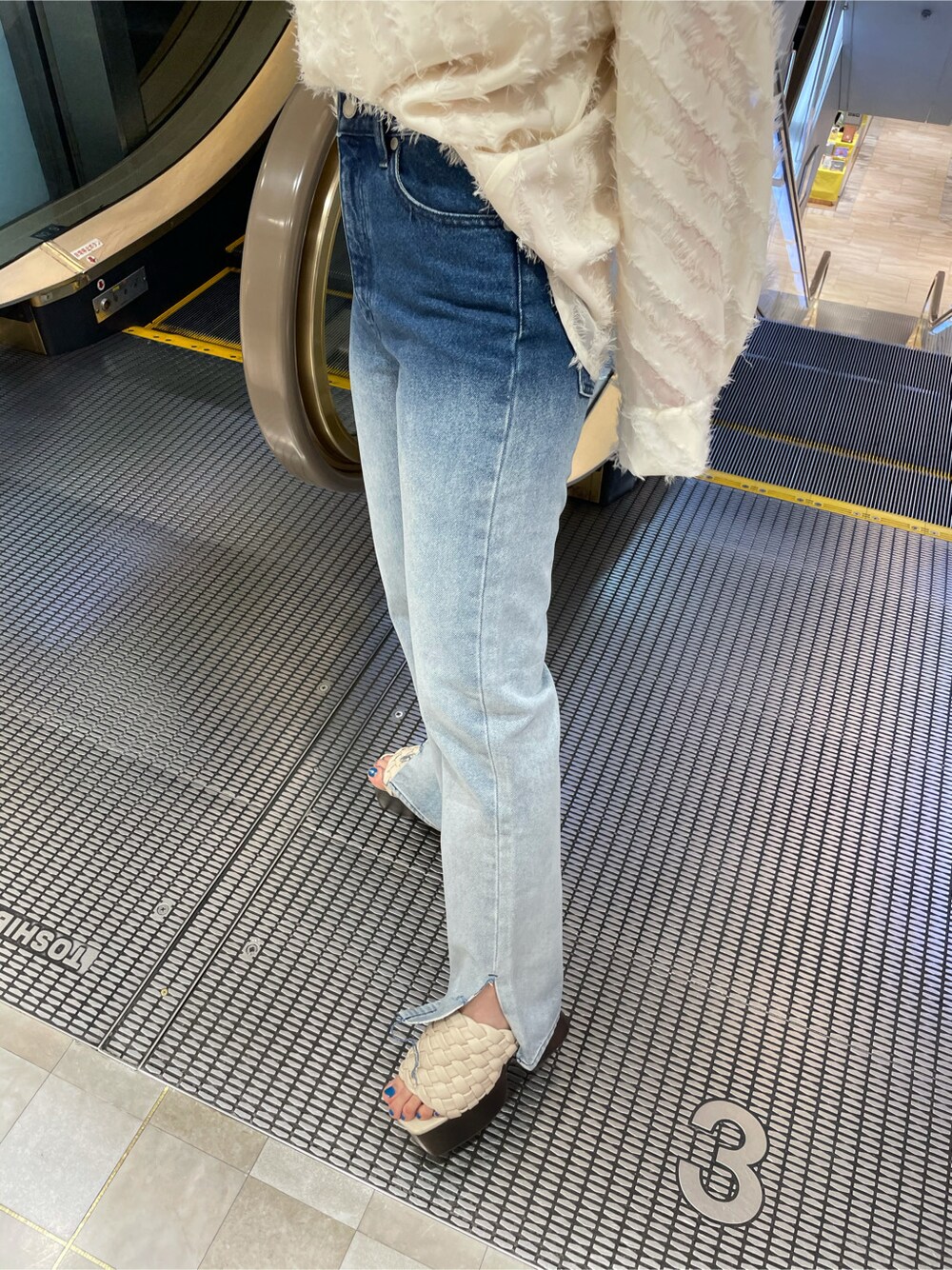 ホワイト系のサンダル、ブルー系のデニムパンツ、ホワイト系のTシャツ/カットソーを着用したレディースの春コーディネートの4枚目の写真