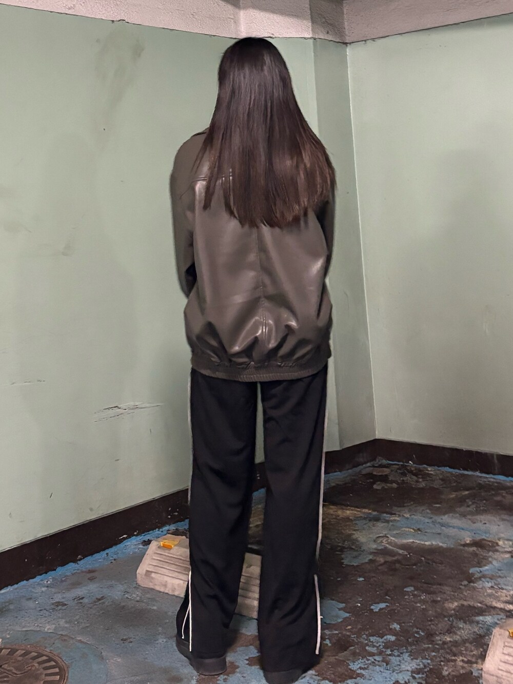 ブラック系のスラックス、ブラック系のローファー、グレー系のブルゾンを着用したレディースの冬コーディネートの3枚目の写真