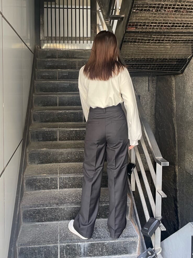 ブラック系のスラックス、ホワイト系のスウェット、シルバー系のネックレスを着用したレディースの秋コーディネートの3枚目の写真