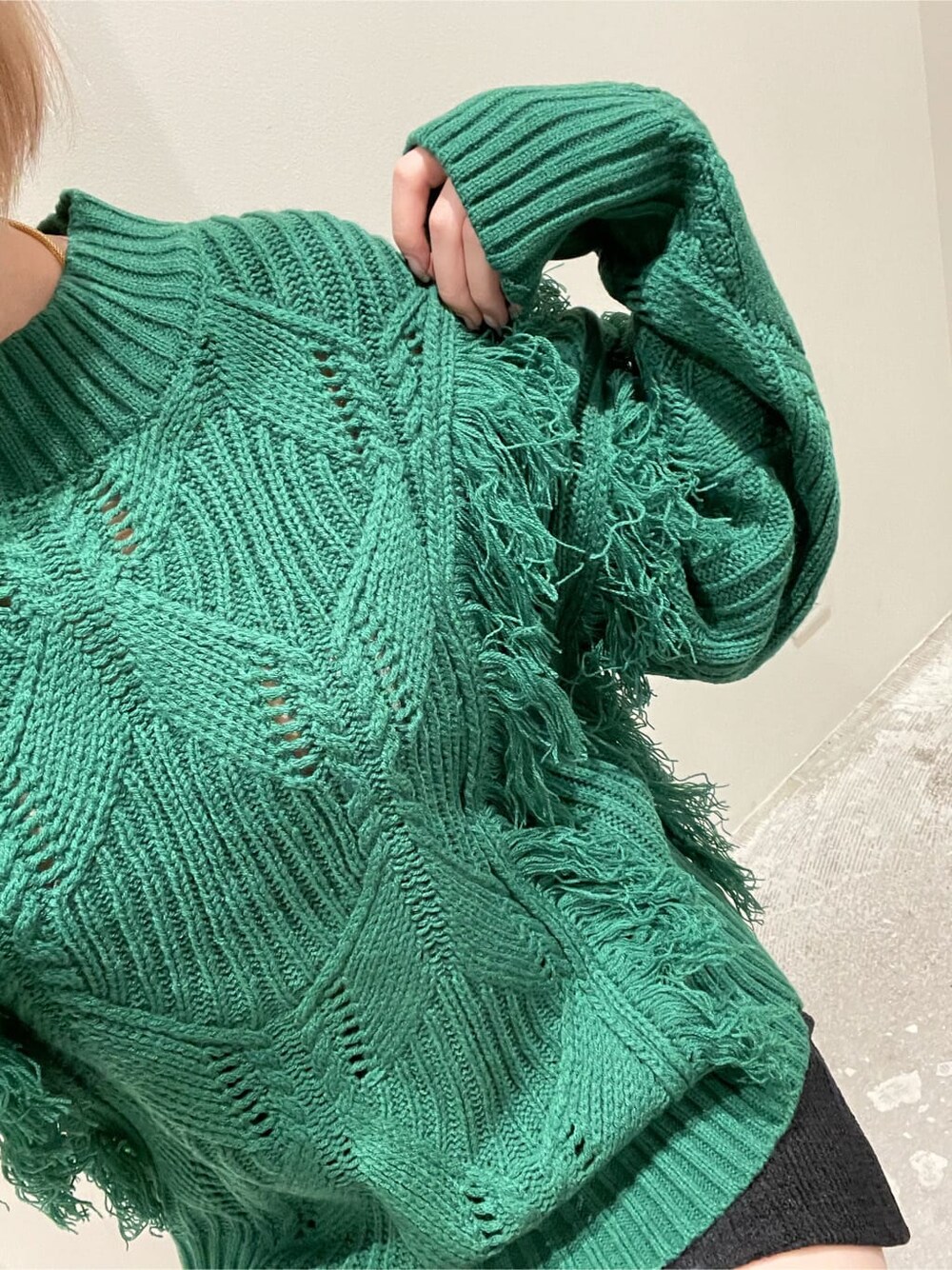 ブラック系のスカート、ブラック系のローファー、グリーン系のニット/セーターを着用したレディースの秋コーディネートの3枚目の写真