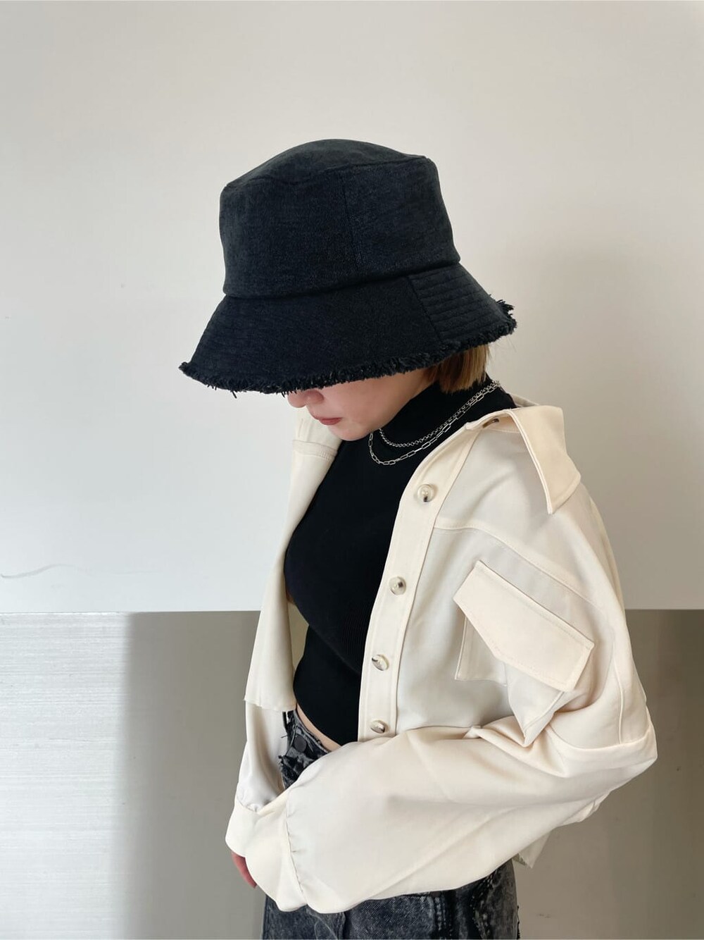 ブラック系のデニムパンツ、ホワイト系のテーラードジャケット、ブラック系のTシャツ/カットソーを着用したレディースの秋コーディネートの3枚目の写真