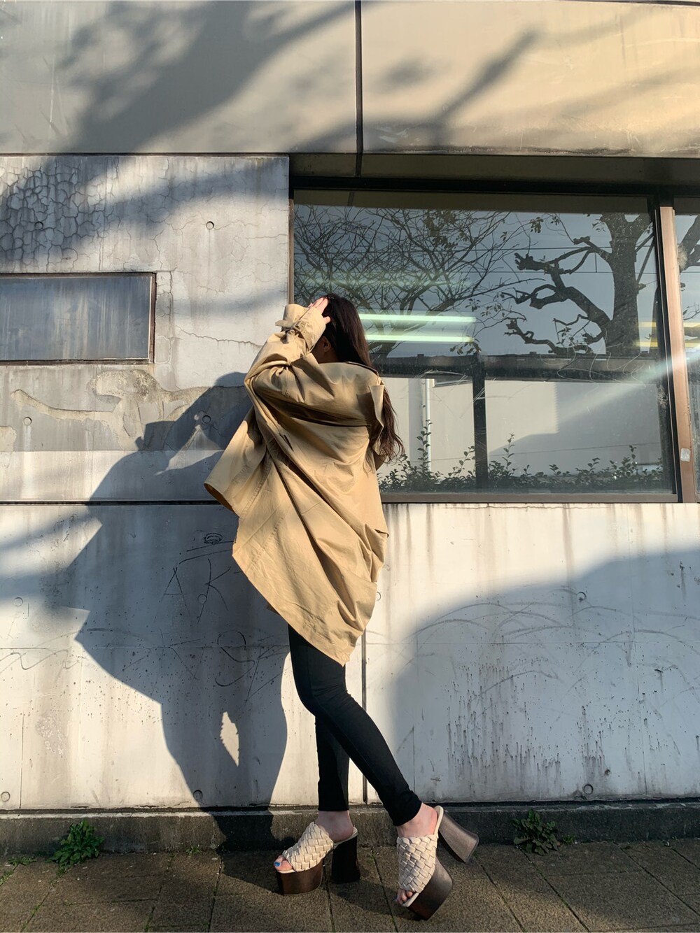 ベージュ系のトレンチコート、ホワイト系のサンダル、その他のニット/セーターを着用したレディースの春コーディネートの3枚目の写真