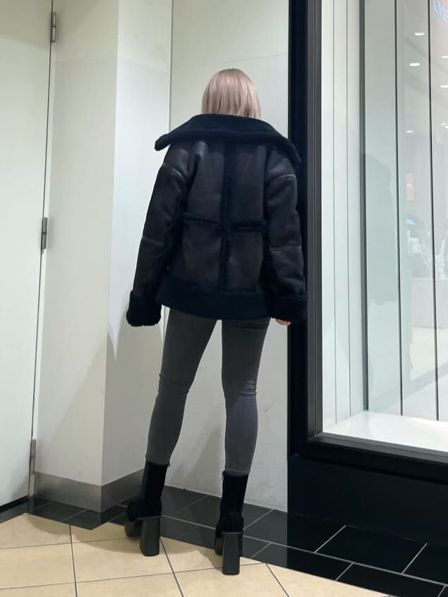 ブラック系のブーツ、グレー系のデニムパンツ、ブラック系のムートンコートを着用したレディースの冬コーディネートの2枚目の写真