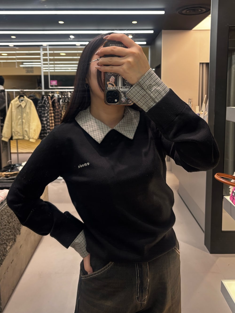 ベージュ系のデニムパンツ、ブラック系のシャツ/ブラウス、ブラック系のスニーカーを着用したレディースの冬コーディネートの3枚目の写真