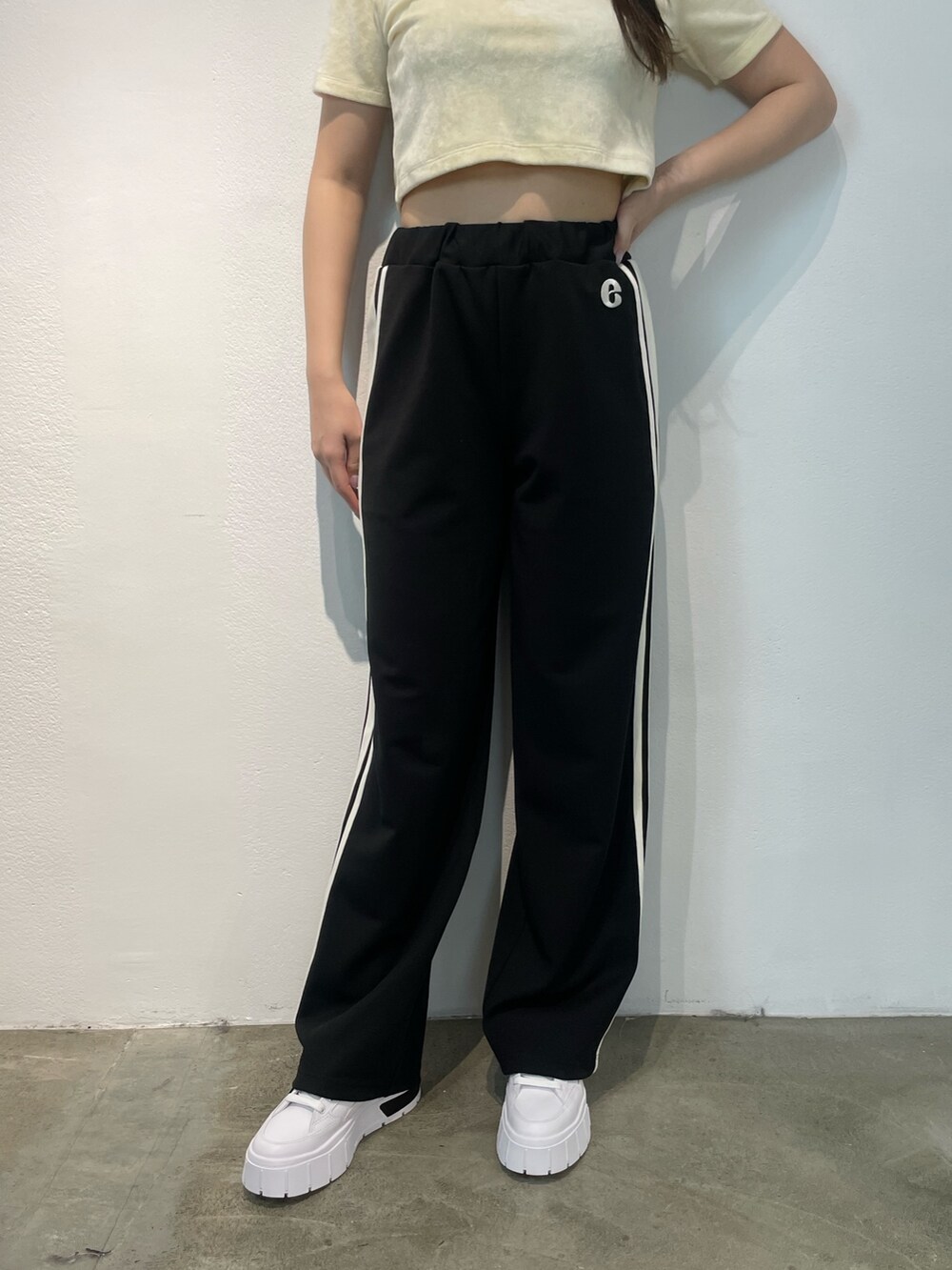 ブラック系のその他パンツ、ホワイト系のTシャツ/カットソー、ブラック系のスニーカーを着用したレディースの夏コーディネートの5枚目の写真