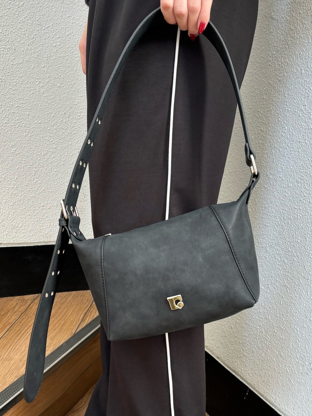 ブラック系のスラックス、ブラック系のニット/セーター、ブラック系のスニーカーを着用したレディースの冬コーディネートの6枚目の写真