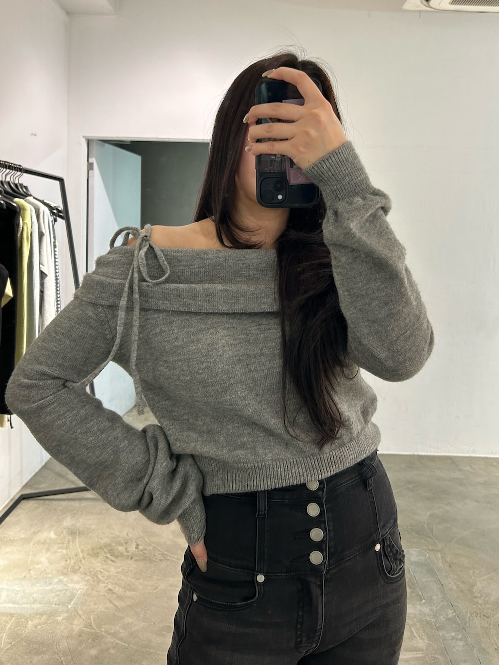 ブラック系のブーツ、ブラック系のデニムパンツ、グレー系のニット/セーターを着用したレディースの秋コーディネートの3枚目の写真