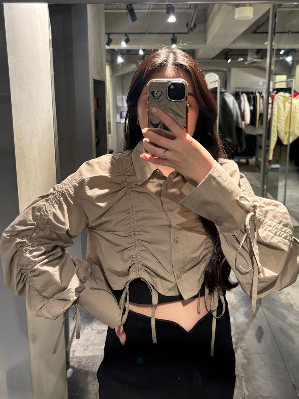 ブラック系のブーツ、ブラック系のスカート、ベージュ系のシャツ/ブラウスを着用したレディースの春コーディネートの3枚目の写真