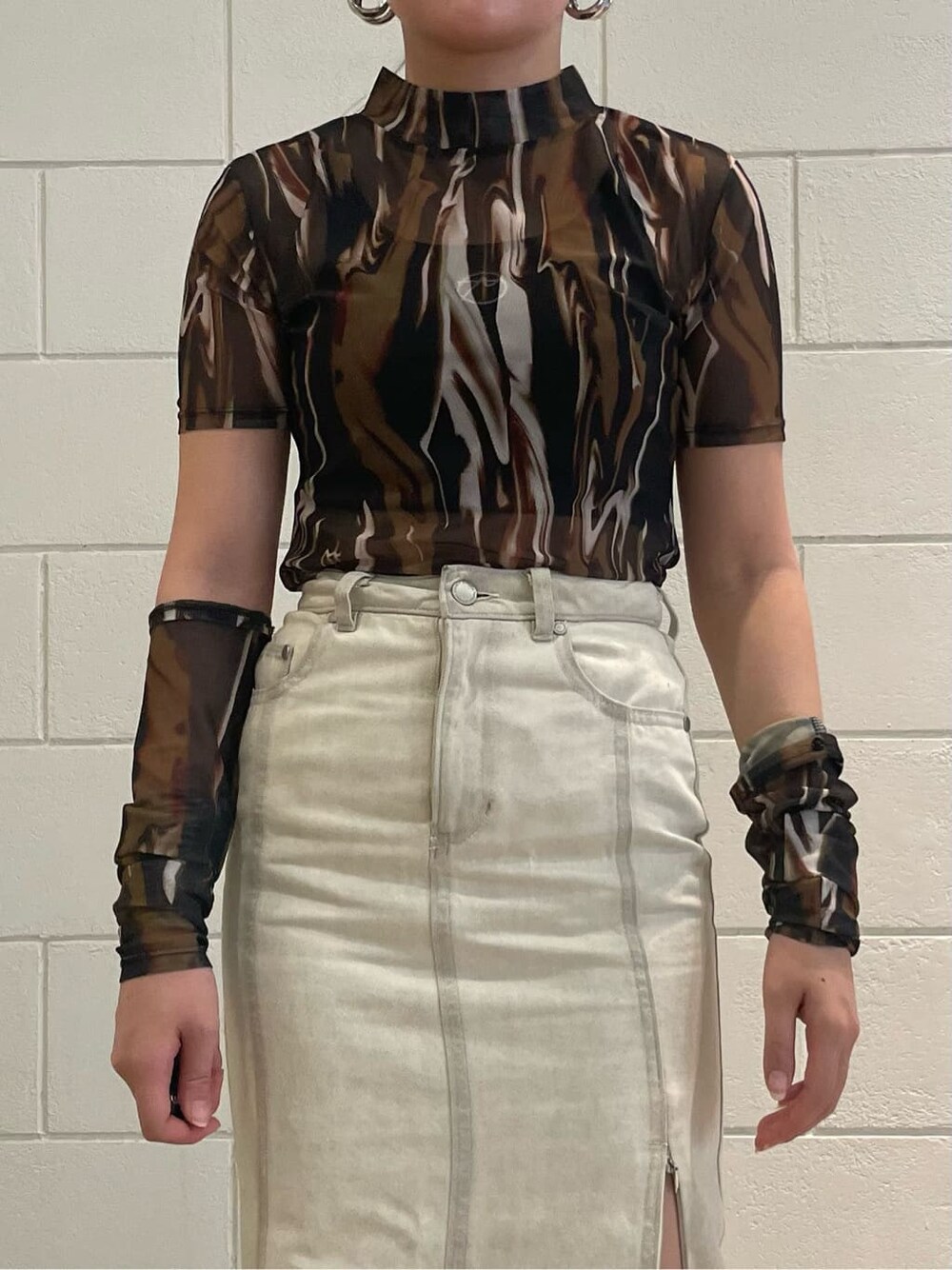 ホワイト系のスカート、ブラック系のブーツ、その他のTシャツ/カットソーを着用したレディースの夏コーディネートの4枚目の写真