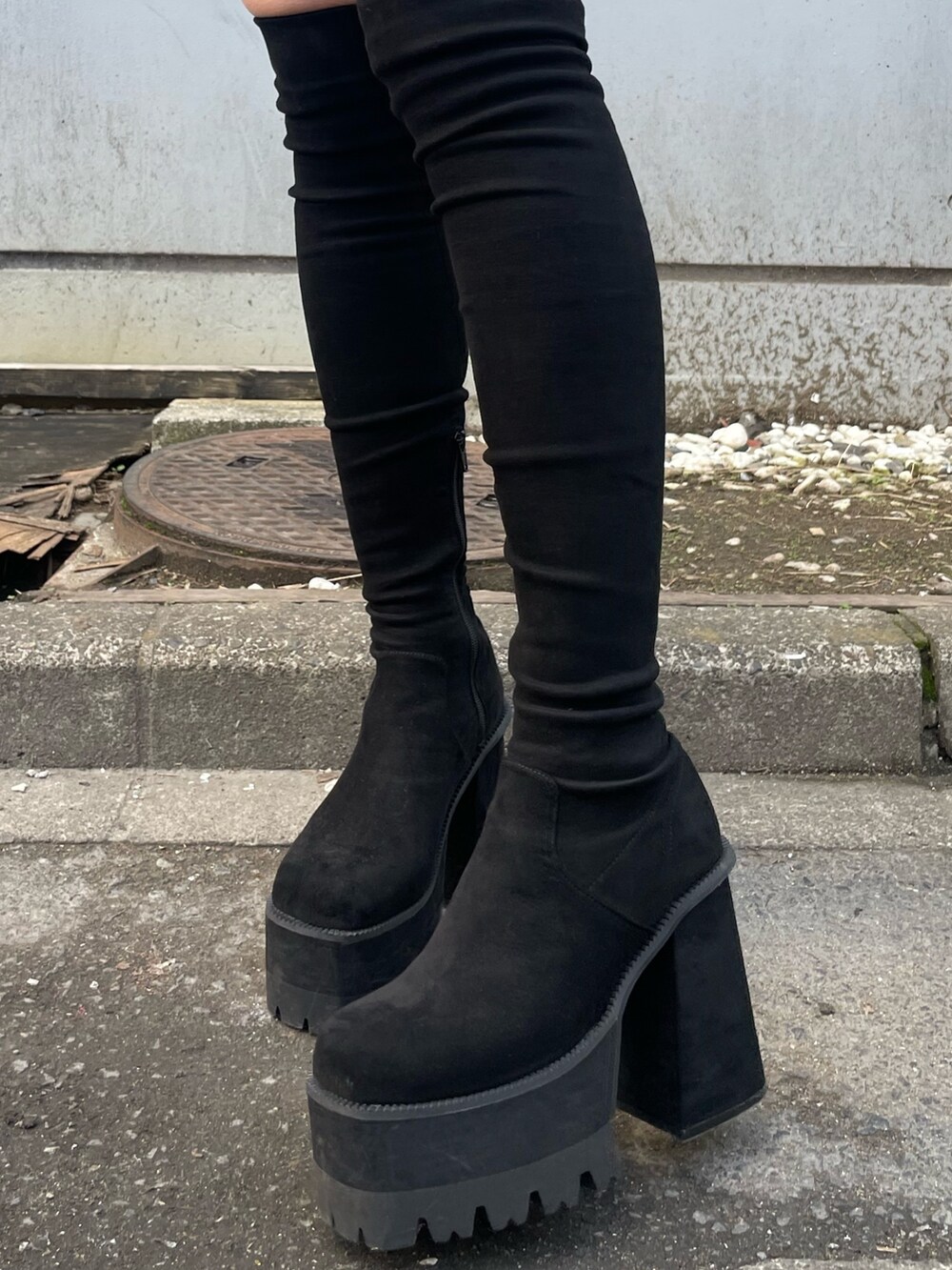 ホワイト系のダウンジャケット/コート、ブラック系のワンピース、ブラック系のブーツを着用したレディースの冬コーディネートの8枚目の写真