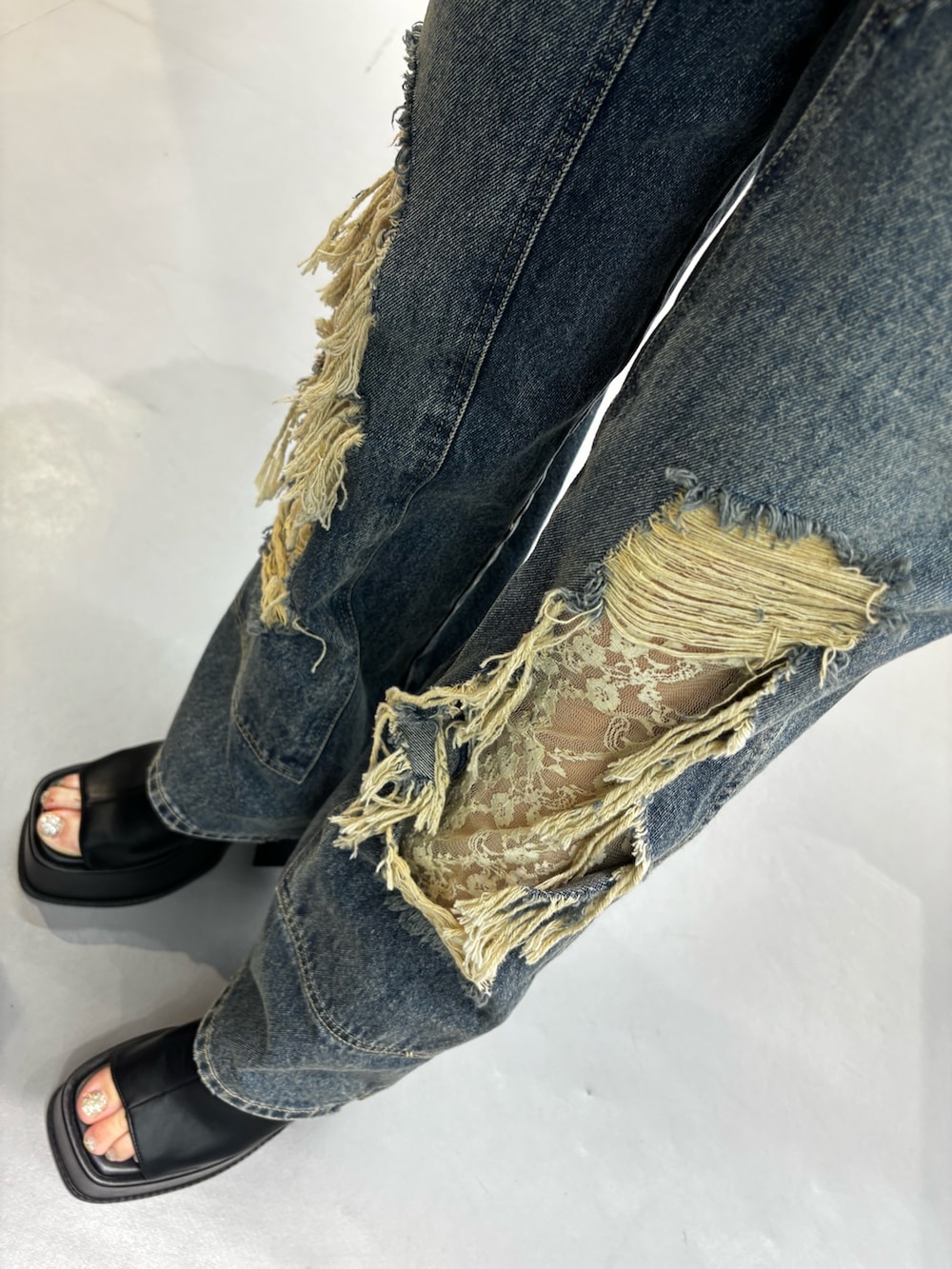 ブラック系のサンダル、ブルー系のデニムパンツ、ブラック系のTシャツ/カットソーを着用したレディースの春コーディネートの4枚目の写真