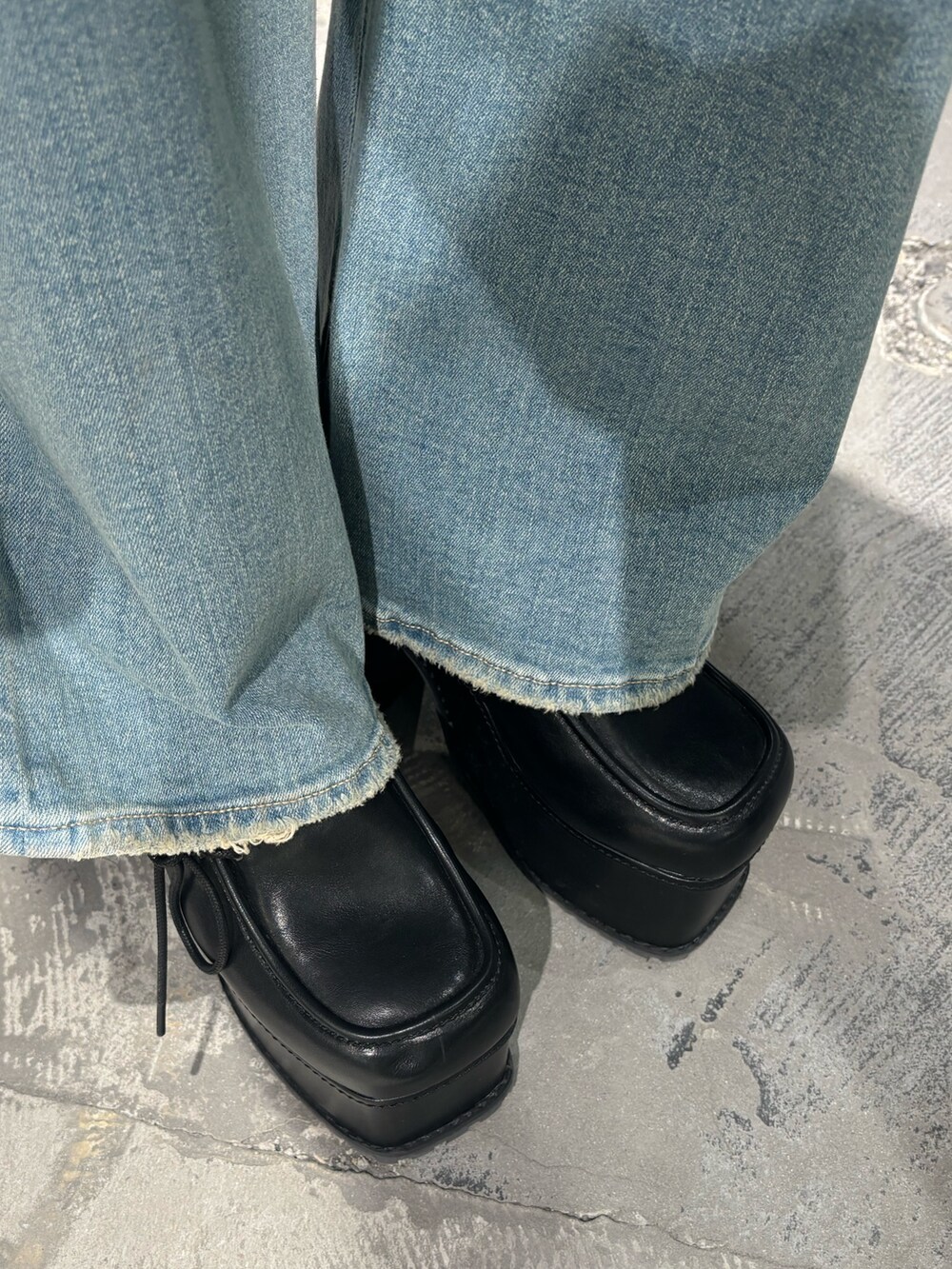 ブルー系のデニムパンツ、ブラック系のサンダル、ホワイト系のTシャツ/カットソーを着用したレディースの春コーディネートの7枚目の写真