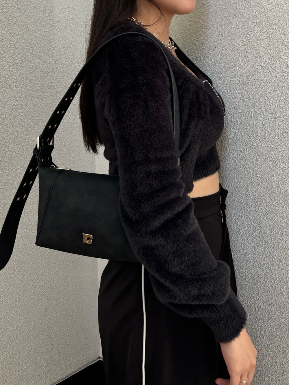 ブラック系のスラックス、ブラック系のニット/セーター、ブラック系のスニーカーを着用したレディースの冬コーディネートの3枚目の写真