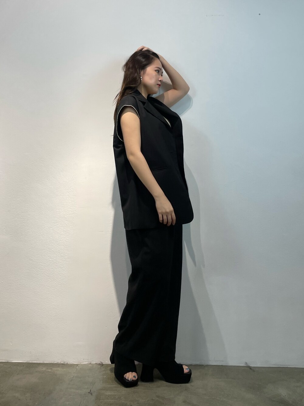 ブラック系のその他パンツ、ブラック系のベスト、ホワイト系のニット/セーターを着用したレディースの夏コーディネートの2枚目の写真