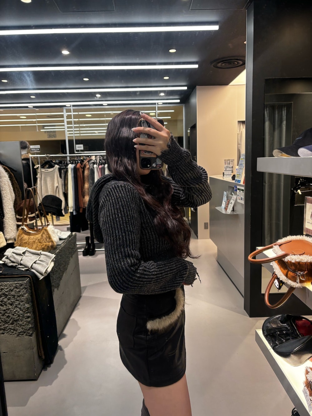 ブラック系のブーツ、ブラック系のスカート、ブラック系のニット/セーターを着用したレディースの冬コーディネートの4枚目の写真