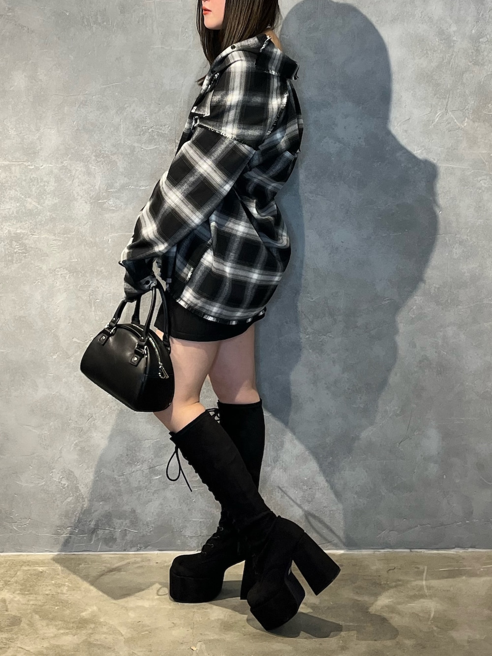 ブラック系のスカート、ブラック系のブーツ、ブラック系のシャツ/ブラウスを着用したレディースの冬コーディネートの2枚目の写真