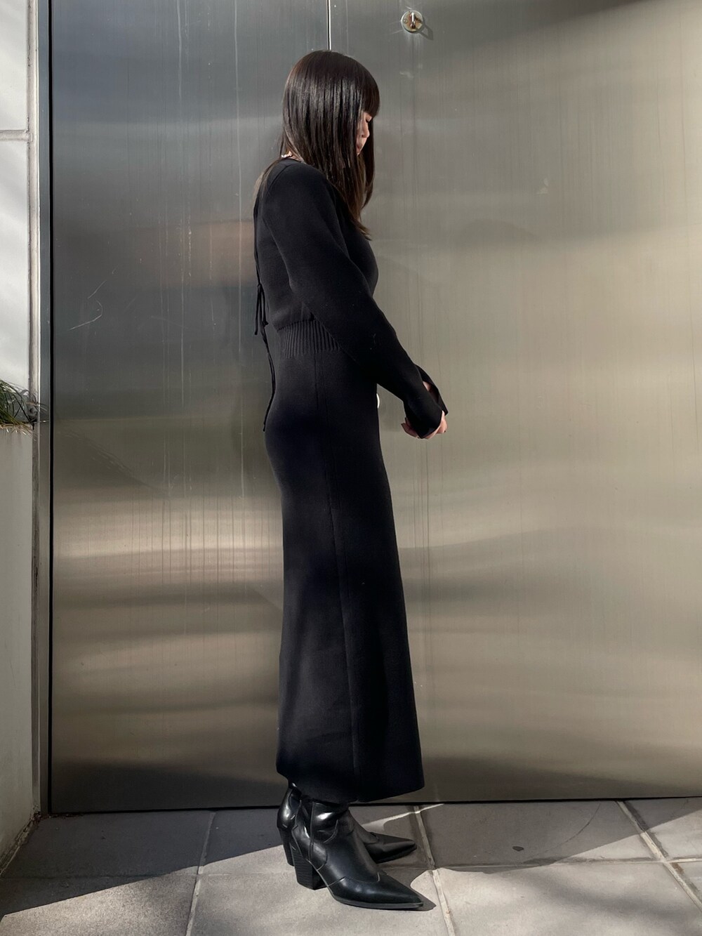 グレー系のブルゾン、ブラック系のワンピース、ブラック系のブーツを着用したレディースの冬コーディネートの9枚目の写真