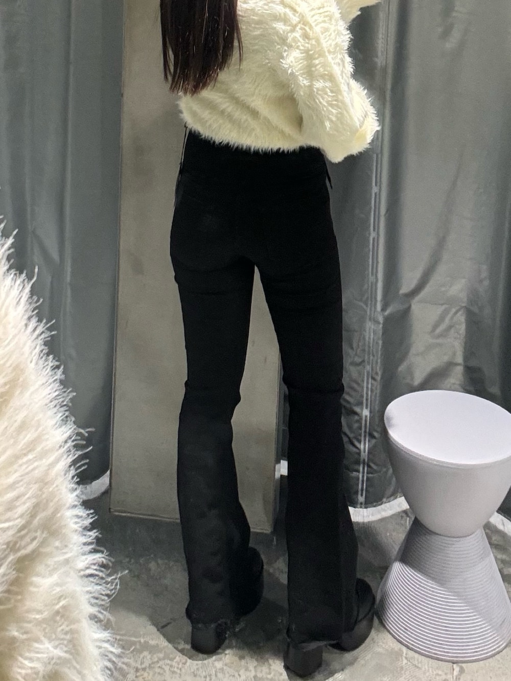 ブラック系のデニムパンツ、ホワイト系のニット/セーター、ブラック系のブーツを着用したレディースの冬コーディネートの3枚目の写真