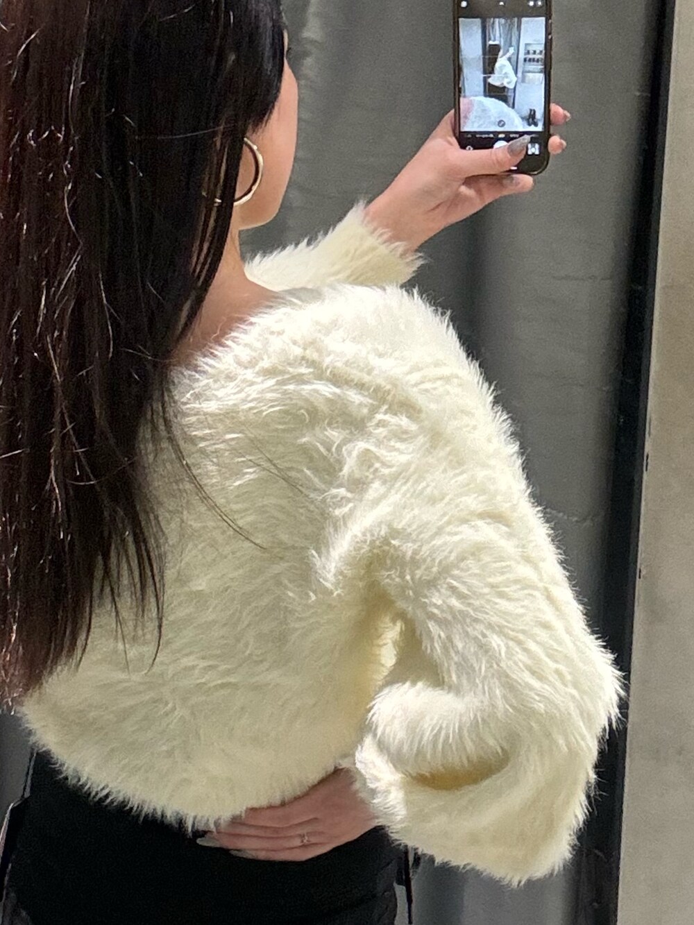 ブラック系のデニムパンツ、ホワイト系のニット/セーター、ブラック系のブーツを着用したレディースの冬コーディネートの7枚目の写真