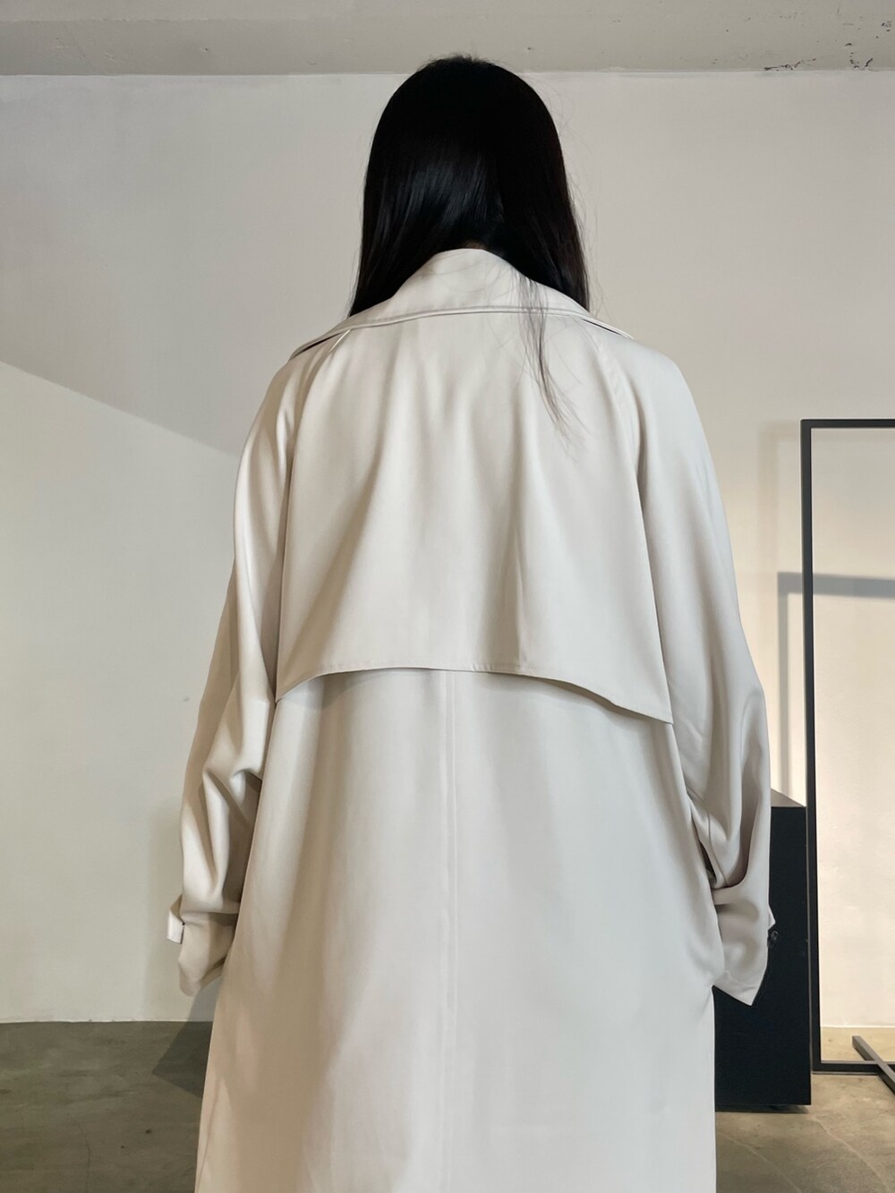 グリーン系のトレンチコート、ブラック系のパンプス、ブルー系のデニムパンツを着用したレディースの冬コーディネートの7枚目の写真