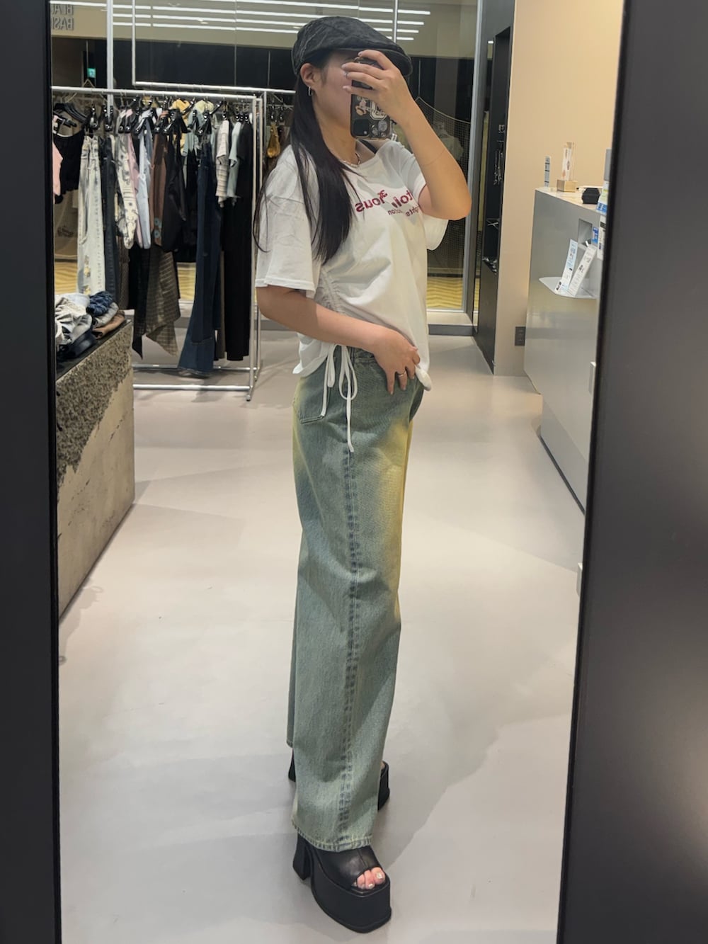 ブラック系のサンダル、ブルー系のデニムパンツ、ホワイト系のTシャツ/カットソーを着用したレディースの春コーディネートの2枚目の写真
