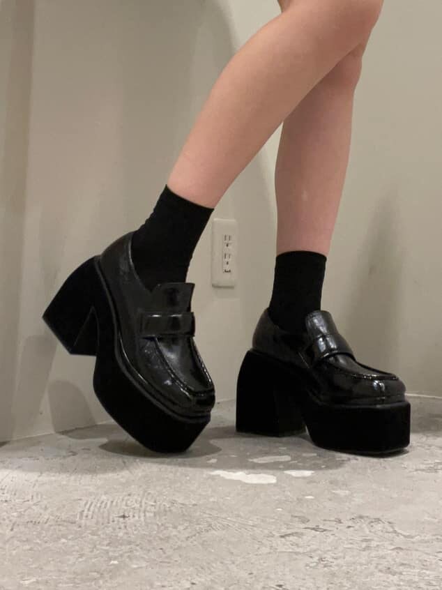 ブラック系のスカート、ブラック系のローファー、グリーン系のニット/セーターを着用したレディースの秋コーディネートの6枚目の写真