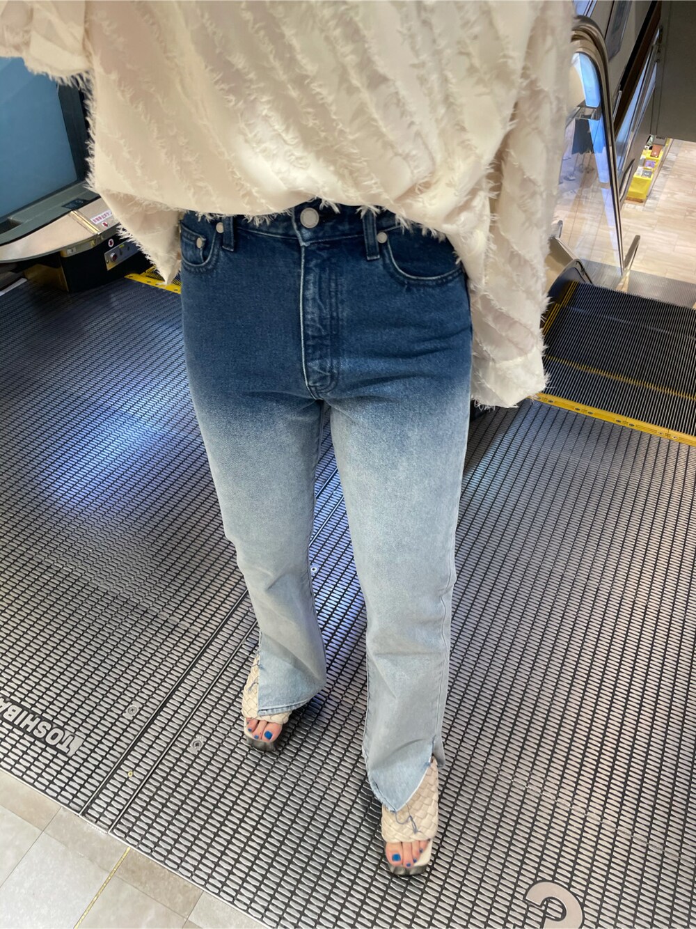 ホワイト系のサンダル、ブルー系のデニムパンツ、ホワイト系のTシャツ/カットソーを着用したレディースの春コーディネートの5枚目の写真