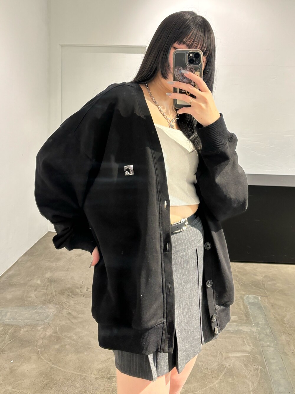 ブラック系のスカート、ブラック系のカーディガン/ボレロ、ブラック系のキャミソールを着用したレディースの春コーディネートの6枚目の写真