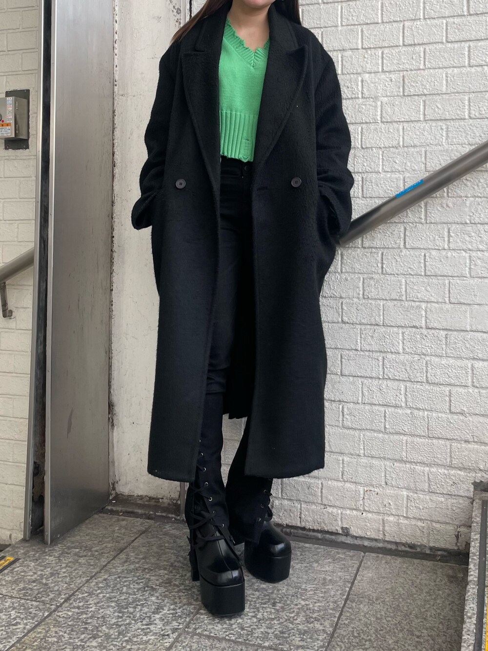 パープル系のチェスターコート、パープル系のニット/セーター、ブラック系のデニムパンツを着用したレディースの冬コーディネートの4枚目の写真