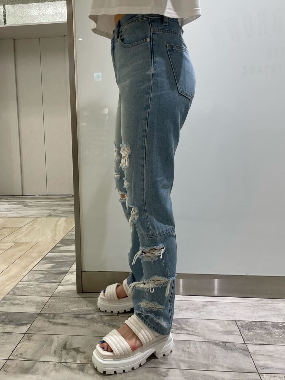 ホワイト系のサンダル、ブルー系のデニムパンツ、ホワイト系のTシャツ/カットソーを着用したレディースの夏コーディネートの6枚目の写真