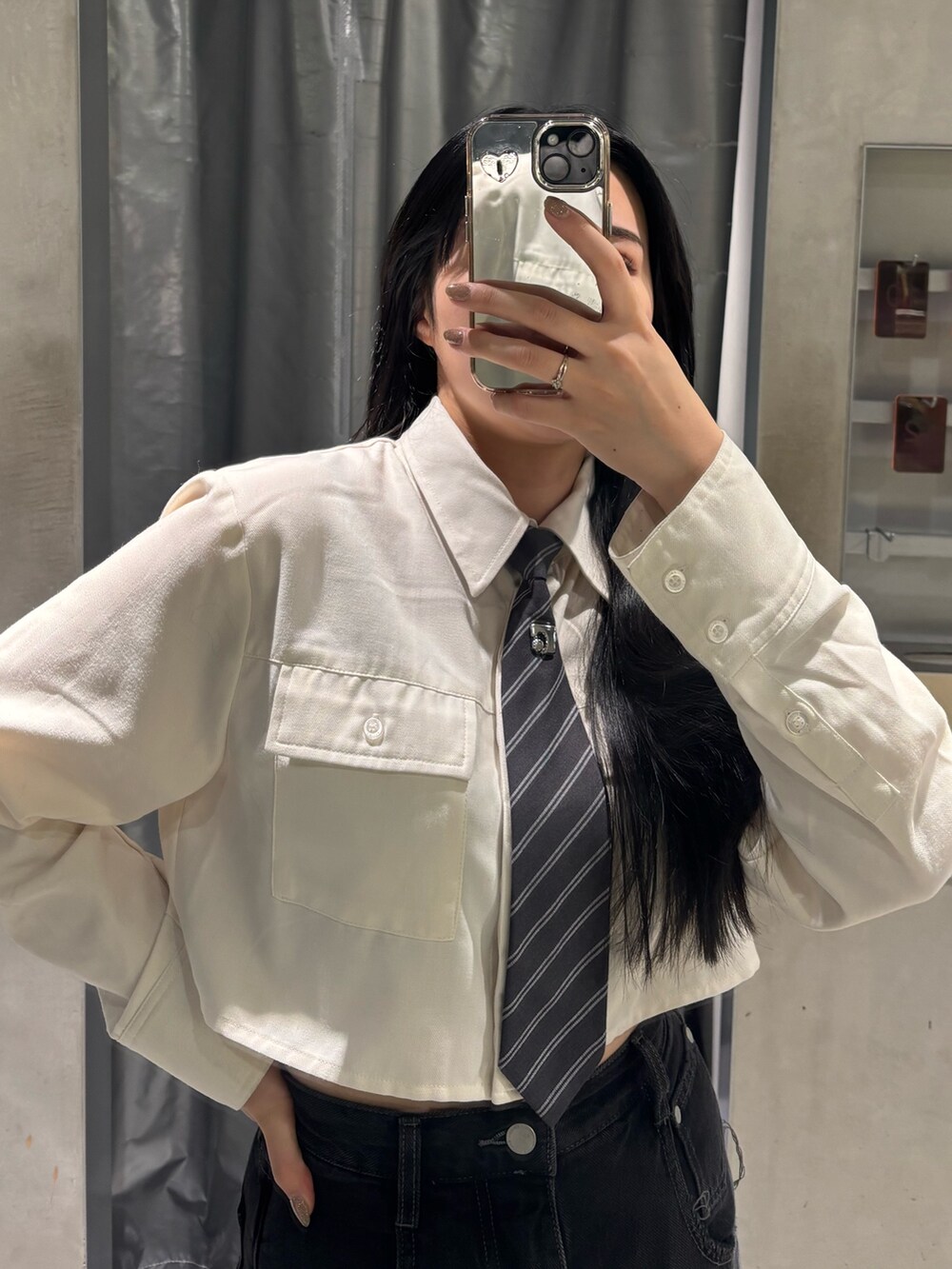 ブラック系のデニムパンツ、ブラック系のブーツ、ホワイト系のシャツ/ブラウスを着用したレディースの秋コーディネートの3枚目の写真