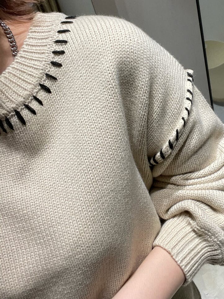 ブラック系のブルゾン、ホワイト系のブーツ、ホワイト系のニット/セーターを着用したレディースの冬コーディネートの4枚目の写真