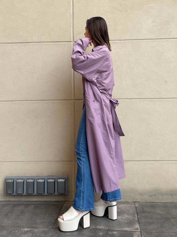 パープル系のトレンチコート、ホワイト系のキャミソール、ホワイト系のサンダルを着用したレディースの春コーディネートの2枚目の写真