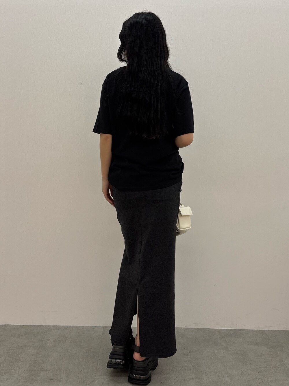 グレー系のサンダル、ブラック系のスカート、ブラック系のTシャツ/カットソーを着用したレディースの春コーディネートの2枚目の写真