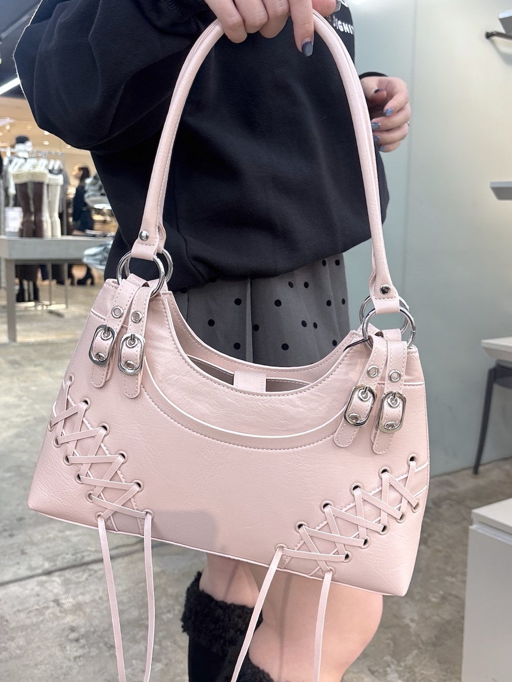 ブラック系のブーツ、グレー系のスカート、ブラック系のショルダーバッグを着用したレディースの秋コーディネートの5枚目の写真