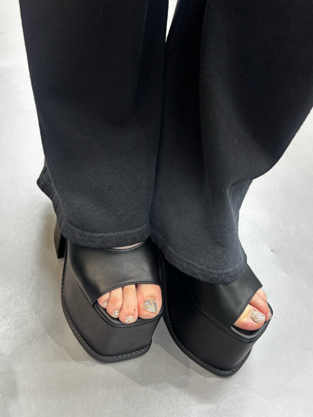 ブラック系のサンダル、グレー系のスウェットパンツ、ブラック系のその他トップスを着用したレディースの春コーディネートの5枚目の写真