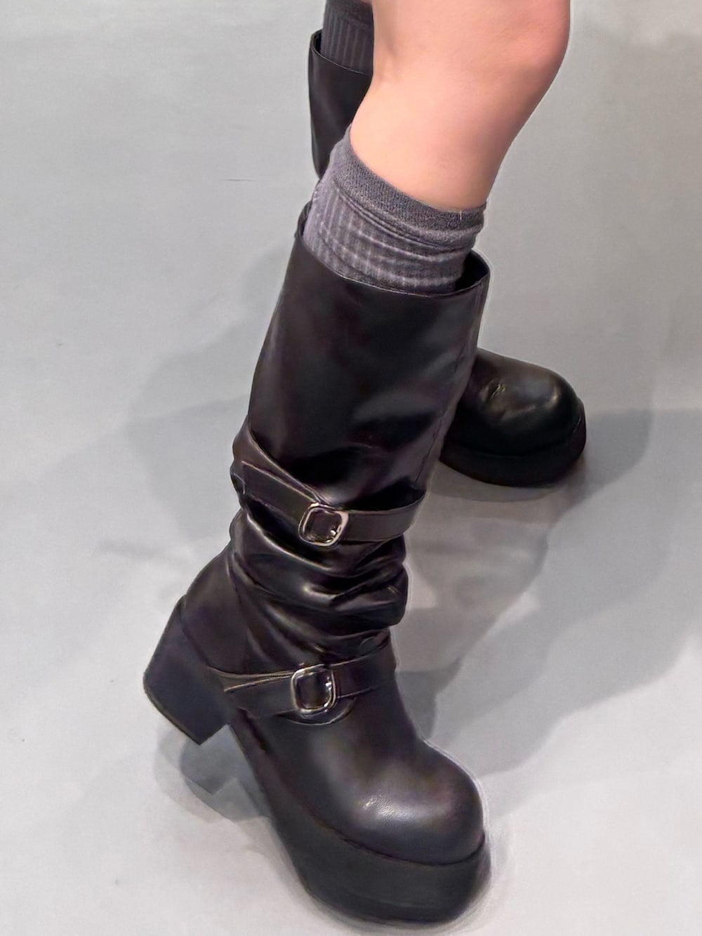 ブラック系のブーツ、イエロー系のスカート、イエロー系のブルゾンを着用したレディースの冬コーディネートの5枚目の写真