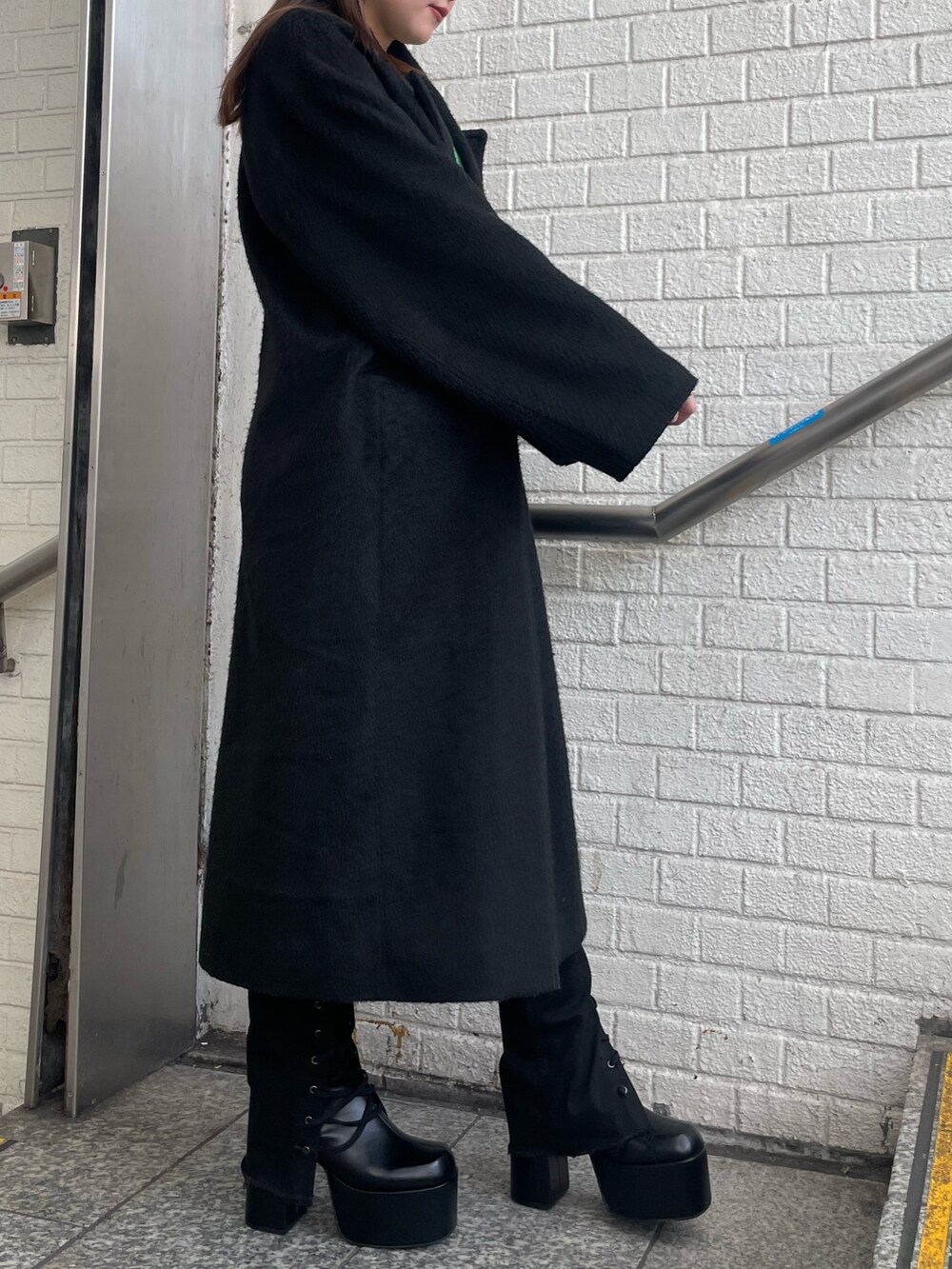 パープル系のチェスターコート、パープル系のニット/セーター、ブラック系のデニムパンツを着用したレディースの冬コーディネートの2枚目の写真