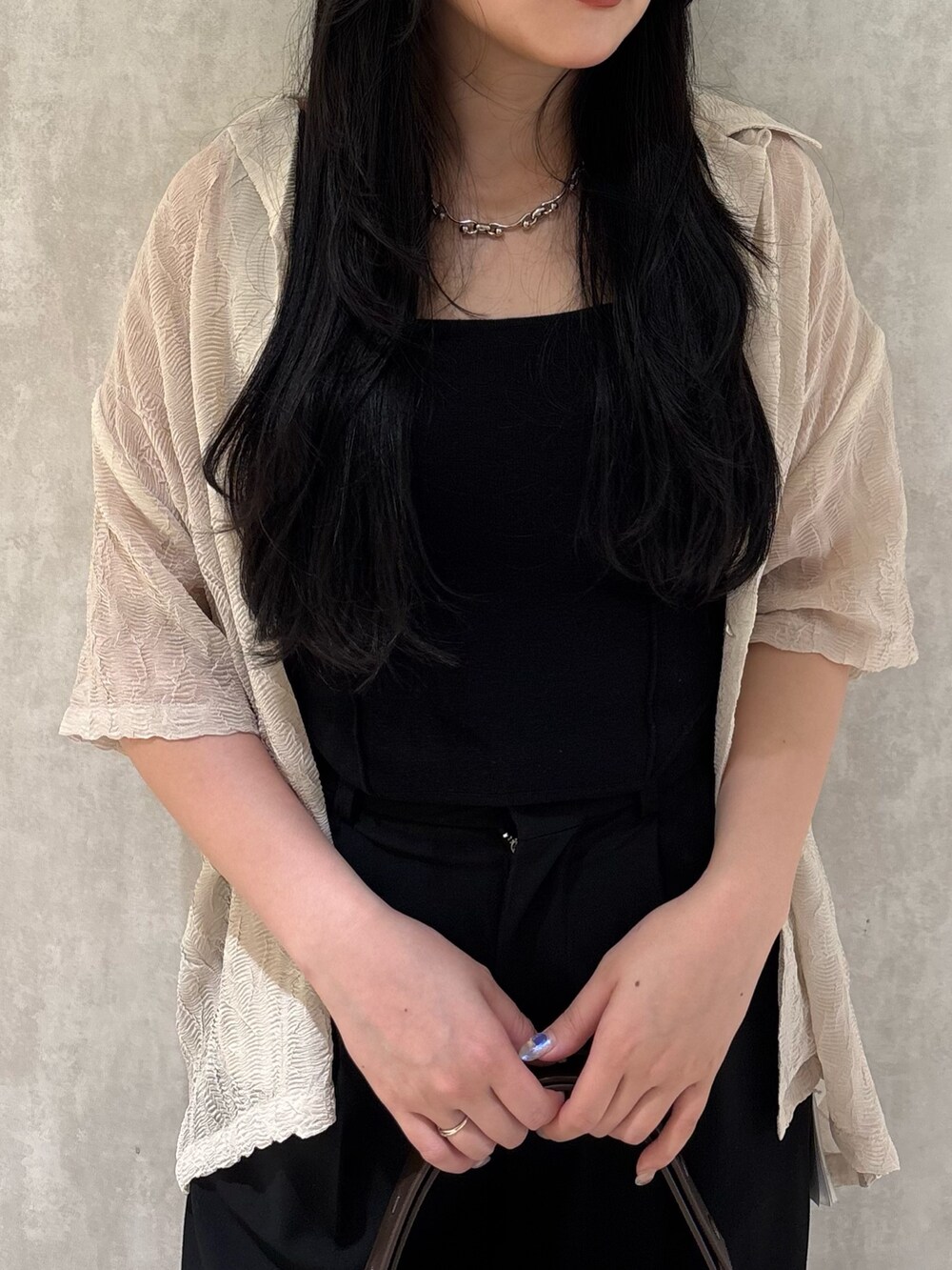 グレー系のその他パンツ、ブラック系のニット/セーター、ホワイト系のシャツ/ブラウスを着用したレディースの夏コーディネートの3枚目の写真