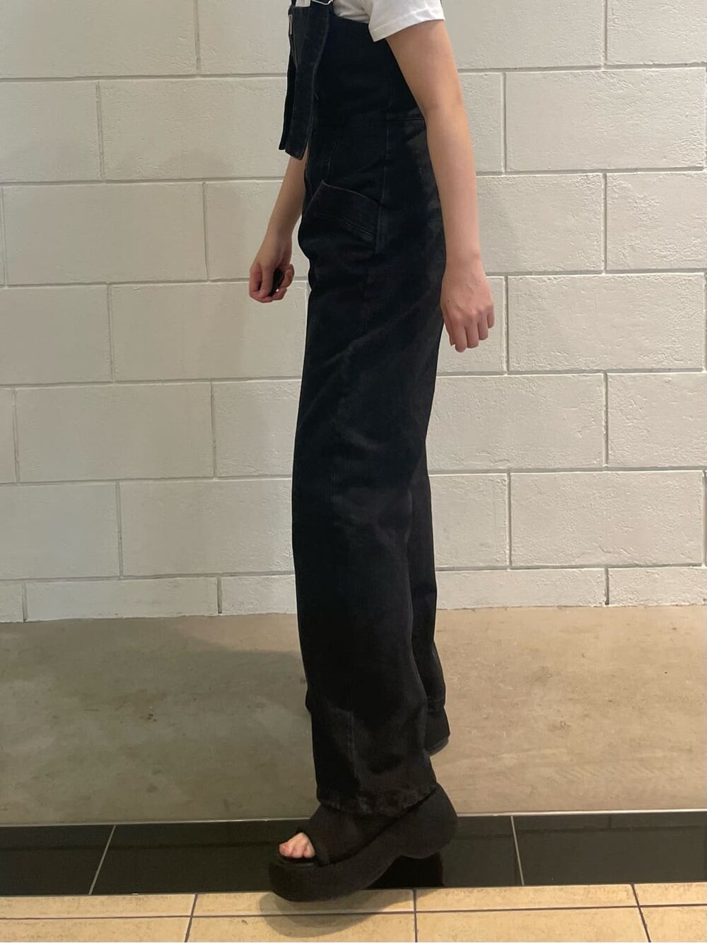 ブラック系のサンダル、ブラック系のつなぎ/オールインワン、ホワイト系のTシャツ/カットソーを着用したレディースの夏コーディネートの6枚目の写真