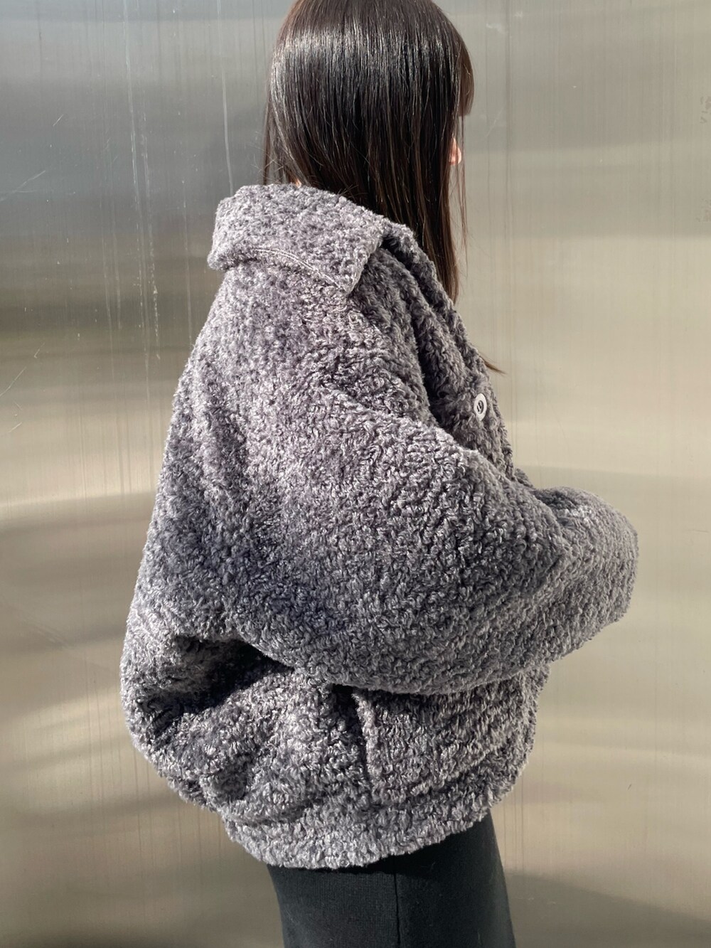 グレー系のブルゾン、ブラック系のワンピース、ブラック系のブーツを着用したレディースの冬コーディネートの5枚目の写真