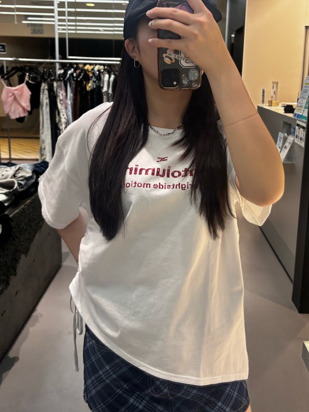 ブラック系のスニーカー、ホワイト系のTシャツ/カットソー、ブルー系のスカートを着用したレディースの春コーディネートの3枚目の写真