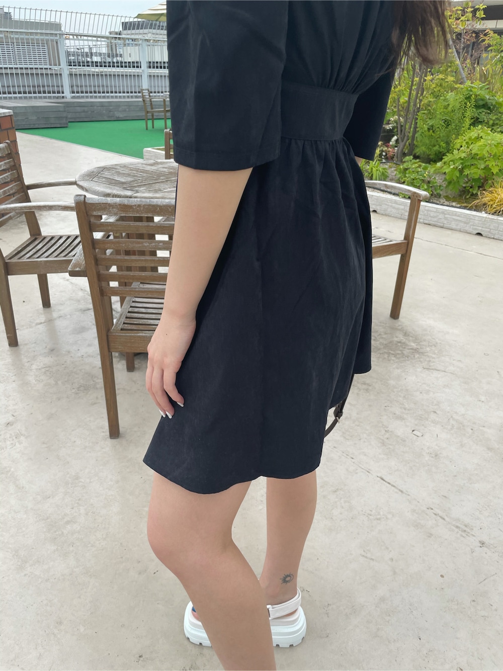 ブラック系のワンピース、ホワイト系のサンダル、ホワイト系のハットを着用したレディースの春コーディネートの4枚目の写真