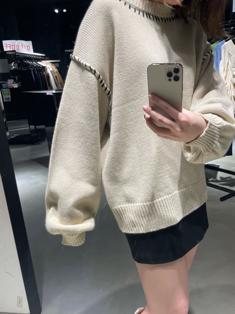 ブラック系のブルゾン、ホワイト系のブーツ、ホワイト系のニット/セーターを着用したレディースの冬コーディネートの5枚目の写真