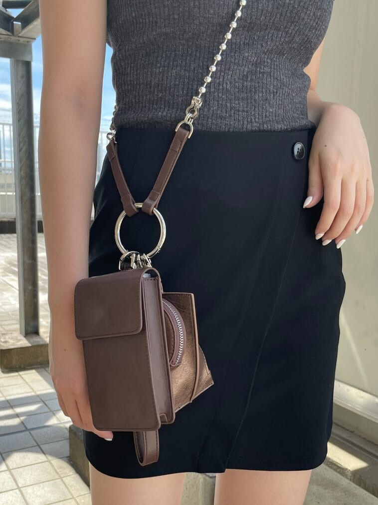 ブラウン系のハンドバッグ、ブラック系のサンダル、ブラック系のスカートを着用したレディースの夏コーディネートの5枚目の写真