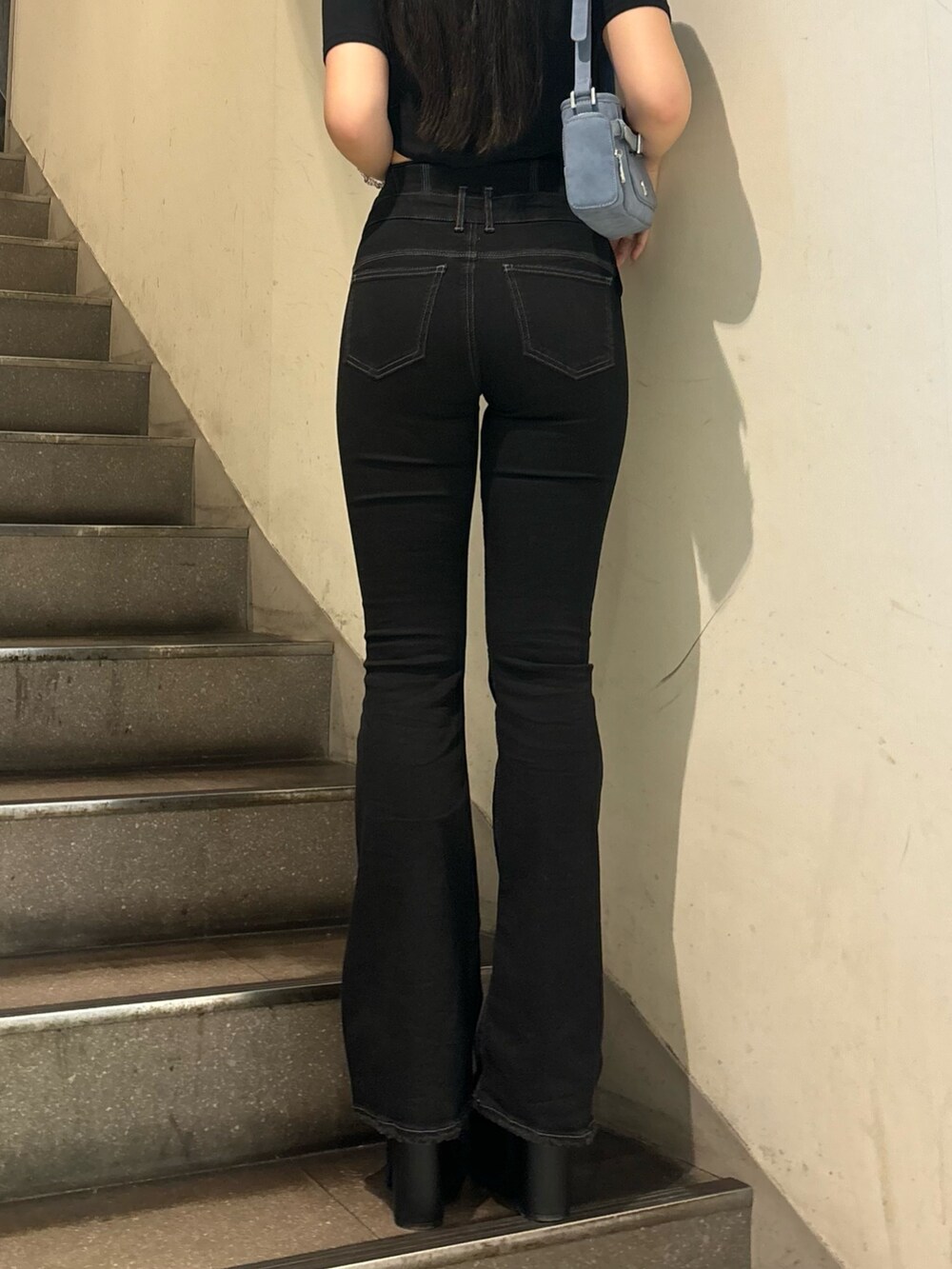 ブラック系のデニムパンツ、ホワイト系のサンダル、ブラック系のTシャツ/カットソーを着用したレディースの夏コーディネートの6枚目の写真